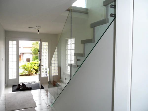 Clear glass railing alongside a residential staircase